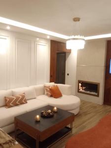 uma sala de estar com um sofá branco e uma lareira em El fal em Dar Bouazza