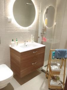 uma casa de banho com um lavatório, um WC e um espelho. em El fal em Dar Bouazza