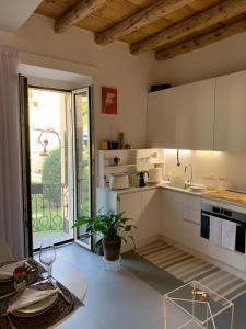 a kitchen with white cabinets and a large window at Villa Paola - Holiday Apartment - Menaggio, Lago di Como in Menaggio