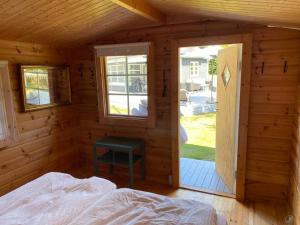 1 dormitorio en una cabaña de madera con cama y ventana en Skønneste hus, en Dannemare