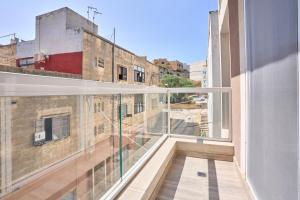 un balcón con vista a un edificio en Gzira Highly Finished Apartment, en Il-Gżira