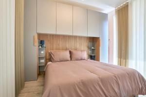 1 dormitorio con 1 cama grande con sábanas rosas en Gzira Highly Finished Apartment, en Il-Gżira
