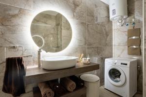 Un baño con lavabo y lavadora. en Gzira Highly Finished Apartment, en Il-Gżira 9 fotos más