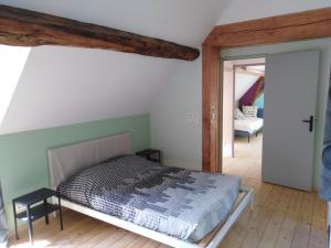 ein Schlafzimmer mit einem Bett in einem Zimmer in der Unterkunft Gîte mon p'ti bout in Les Roches-lʼÉvêque