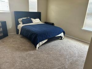 een slaapkamer met een bed met een blauwe deken bij Hme Away from Hme in San Antonio