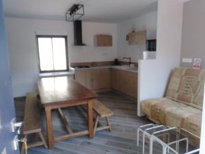 a kitchen with a table and a couch in a room at Gîte mon p'ti bout in Les Roches-lʼÉvêque