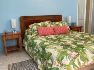 a bedroom with a bed with a red pillow on it at Mango Cove Villa 