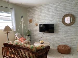 a living room with a couch and a tv at Mango Cove Villa 