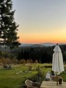 ein weißer Regenschirm auf einem Grasfeld in der Unterkunft Dreisessel Motel in Haidmühle