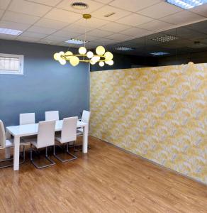 a conference room with a table and chairs and a wall at Hostel Acacias in Madrid