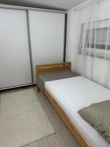 1 dormitorio con 2 camas y ventana en Mimma apartments, en Mostar