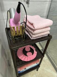 モスタルにあるMimma apartmentsのタオルとピンク色の物が置かれた棚