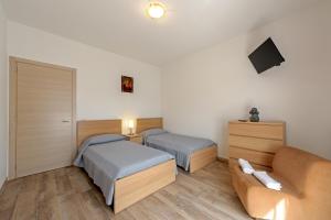 una camera d'albergo con due letti e un divano di CASA REFENERO a Torrita di Siena