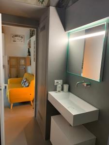 een badkamer met een wastafel en een gele bank bij Villa Paola - Holiday Apartment - Menaggio, Lago di Como in Menaggio