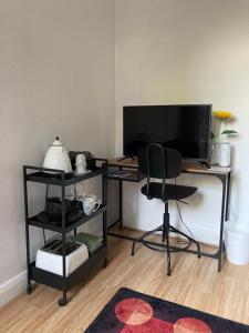 倫敦的住宿－Urban Retreat，一张桌子,电视机和椅子放在房间里