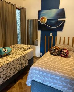 a bedroom with two beds and a painting on the wall at Pousada Recanto Querubim in Siqueira Campos