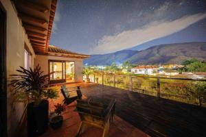 a balcony of a house with a view of the mountains at Casa de las Flores- Buganvilias in Villa de Leyva