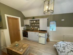 a kitchen with white cabinets and a table in a room at Toddys Hideaway in Cavan
