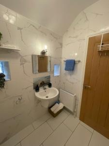 Toddys Hideaway في كافان: حمام أبيض مع حوض ومرحاض