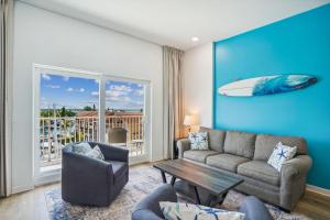 uma sala de estar com um sofá e uma prancha de surf na parede em Madeira Bay Resort I 1505 em St. Pete Beach