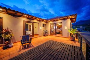 een houten terras met een stoel op een balkon bij Casa de las Flores- Buganvilias in Villa de Leyva