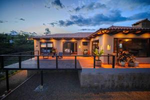 a house with a large deck in front of it at Casa de las Flores- Buganvilias in Villa de Leyva