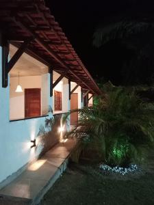 a house with lights on the side of it at night at Pousada Recanto Querubim in Siqueira Campos