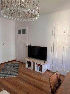 a living room with a television and a chandelier at Ferienwohnung West 2 in Stuttgart
