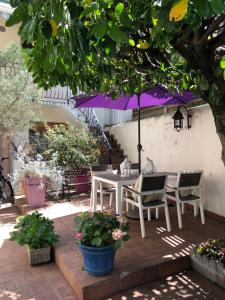 una mesa y sillas con una sombrilla en el patio en Champoiseau, en Tours