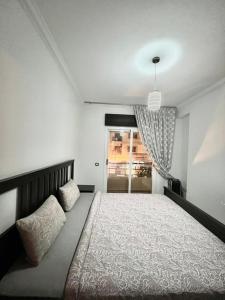 Un dormitorio con una cama grande y una ventana. en Residence meaxpa adres Av Youssef ibn tachfine 4 Tanger, en Tánger
