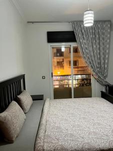 Un dormitorio con una cama grande y una ventana. en Residence meaxpa adres Av Youssef ibn tachfine 4 Tanger, en Tánger