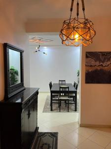 Un comedor con una mesa y una lámpara de araña. en Residence meaxpa adres Av Youssef ibn tachfine 4 Tanger, en Tánger