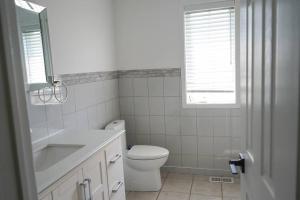 a bathroom with a toilet and a sink and a window at Best staying place in town in Mississauga