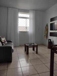 a living room with a couch and a coffee table at Apartamento 2 quartos Setor Sul in Goiânia