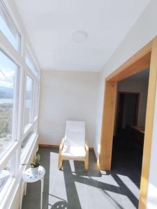 een witte stoel in een kamer met een raam bij Vila María in Castrelo de Miño