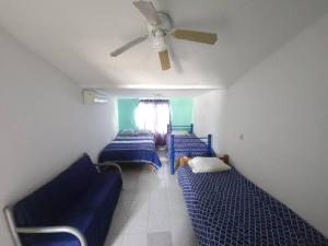 a room with three blue beds and a ceiling fan at Escape Acapulco in Acapulco +13 photos