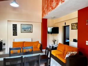 sala de estar con sofá naranja y mesa en Sofias House, en Marantochori