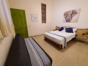 a bedroom with two beds and a green door at Hermosa casa en Cuernavaca cerca de los mejores restaurantes y plazas in Cuernavaca