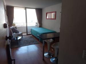 um quarto com uma cama, uma secretária e uma janela em Céntrico Departamento en Santiago em Santiago