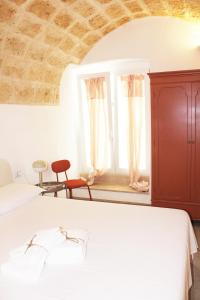 um quarto com uma cama e uma janela em Palazzo Scianni Dimora della Petraia em Monopoli