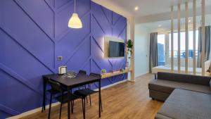 pared púrpura en una sala de estar con mesa en The Jolie Apartments - by the Ocean, en Porto Moniz