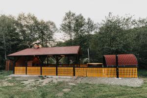 a gazebo with a wooden fence in a park at Forest Garden & House in Izvoare