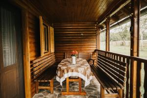 a table on the porch of a cabin at Forest Garden & House in Izvoare