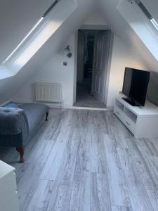 a living room with a couch and a tv on a table at Connemara Ocean Escape in Galway