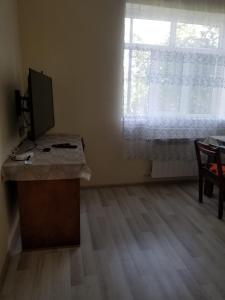 Habitación con escritorio, monitor y ventana. en Sitrus Astara city, 
