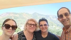 three people posing for a picture with mountains in the background at Hotel affittacamere novella in Tramonti