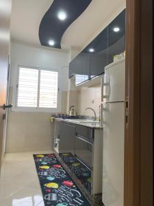 a kitchen with a refrigerator and a rug on the floor at Appartement cosy et pratique in Oujda