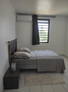 a bedroom with a bed and a window at La Coraline Standing in Kourou