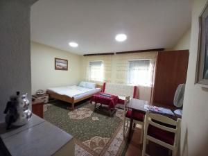 a small living room with a bed and a table at Apartman Turkana 2 in Sarajevo