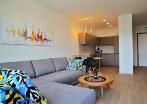 Sala de estar con sofá gris y mesa en Luxury Grand Apartments by Bratislavatrip en Bratislava